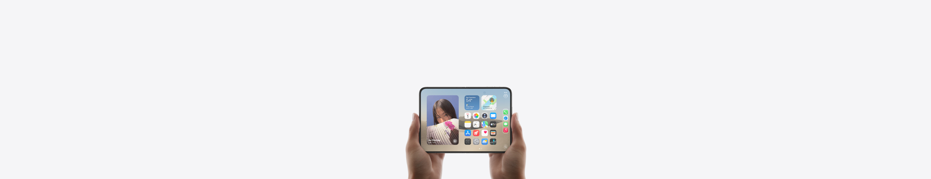 iPhone Duo, bílá barva Star White, drženy v ruce v zavřené poloze, zobrazeny vnější displej, domovská obrazovka iOS s aplikacemi a widgets.