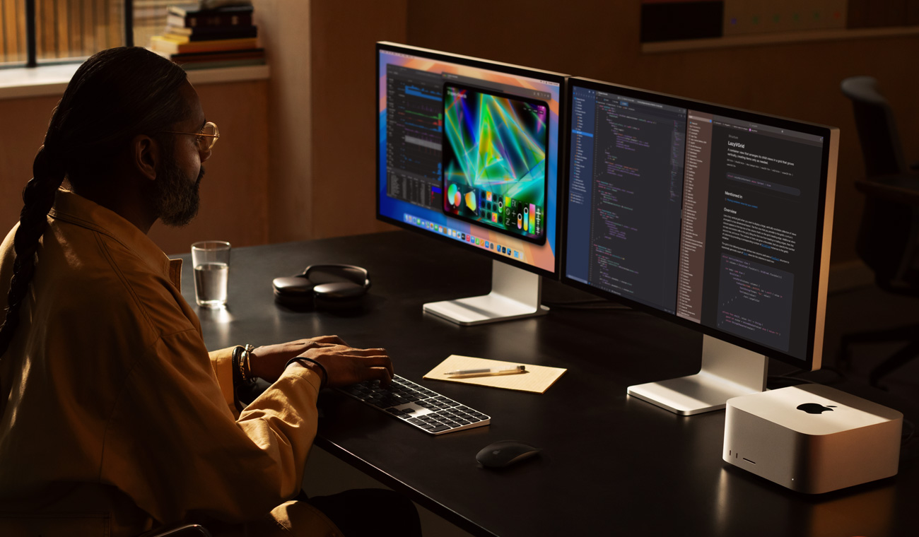 Profesionál pracuje s Macem Studio a dvěma Studio Displayi