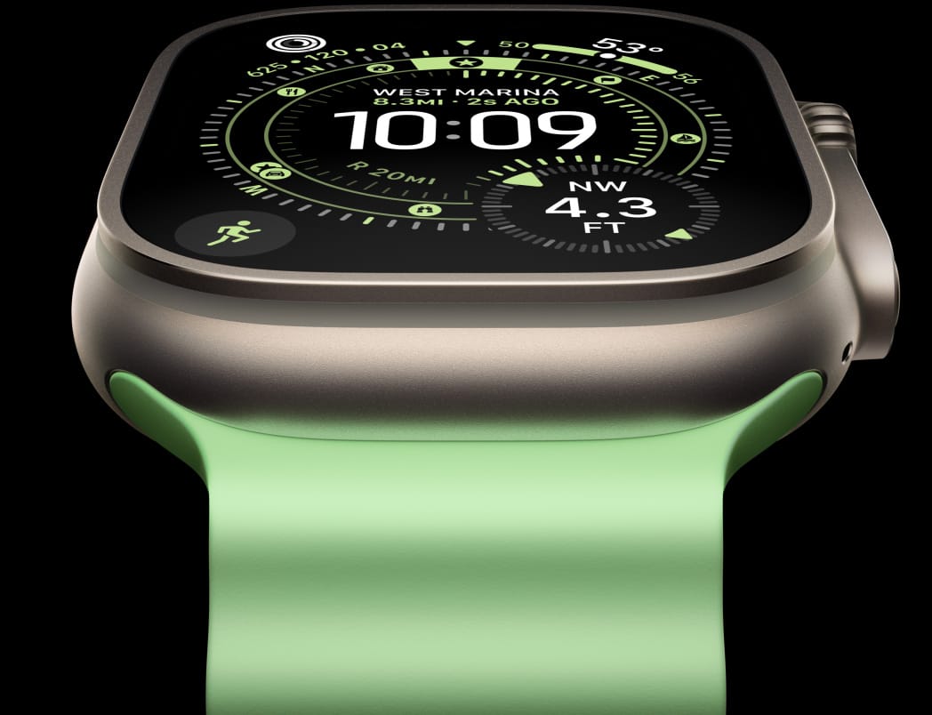 Apple Watch Ultra 3 med urkasse i farven naturligt titanium, kompas på urskiven Orienteringsløb og Ocean-rem i neongrøn