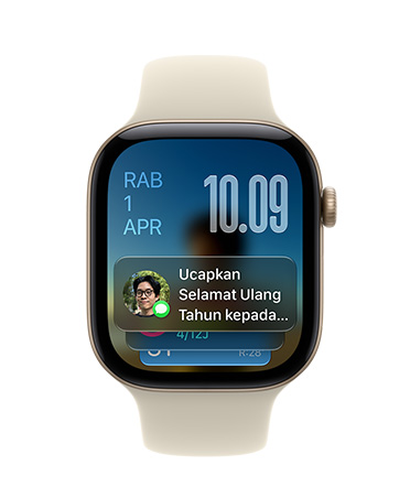 Apple Watch Series 11, Emas Rose dengan tali jam pink lembut, wajah jam menampilkan tanggal di kiri atas, waktu di kanan atas, dan widget Pesan di bagian bawah
