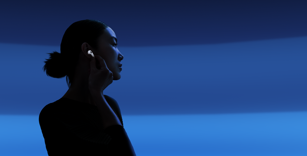 O persoană ținând tija căștilor AirPods 5 între degetul mare și arătător pentru a schimba modurile de ascultare