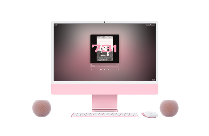 Pembe iMac, ön dış görünüm; ekranda Apple Music çalıyor, aynı renkte Magic Keyboard ve Magic Mouse ile iki pembe HomePod mini 2 hoparlörün stereo çift kurulumu eşliğinde