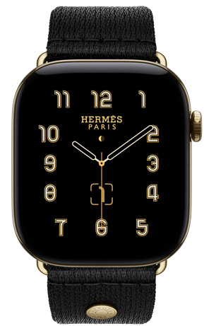 Apple Watch Hermès Series 12, carátula Clou de Selle analógica (agujas de hora, minuto y segundo, complicaciones: fase lunar, fecha), caja de titanio, color oro radiante, parte lateral derecha, Digital Crown, botón lateral, con la correa Noir Satin Clou de Selle, suave tejido satinado negro con componentes en color oro radiante que hacen juego con la caja del reloj
