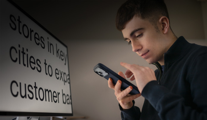 Estudante consulta o iPhone enquanto interage com ele próximo ao rosto