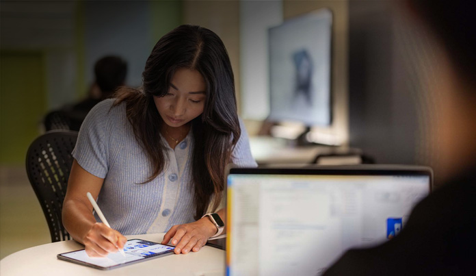Universitária usa o Apple Pencil para fazer anotações em um iPad em um laboratório de tecnologia