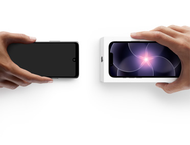 Deux mains côte à côte, l’une tenant un téléphone Android sans boîte, et l’autre tenant un iPhone dix-sept-e neuf dans sa boîte pour effectuer l’échange