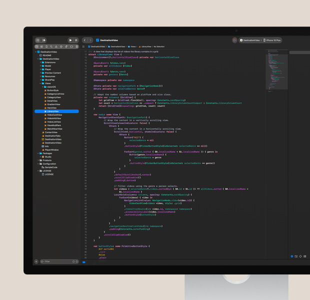 Studio Display 螢幕顯示打開的 Xcode app，展示色彩繽紛的程式碼編輯器，右側可見部分 iPhone app 測試畫面