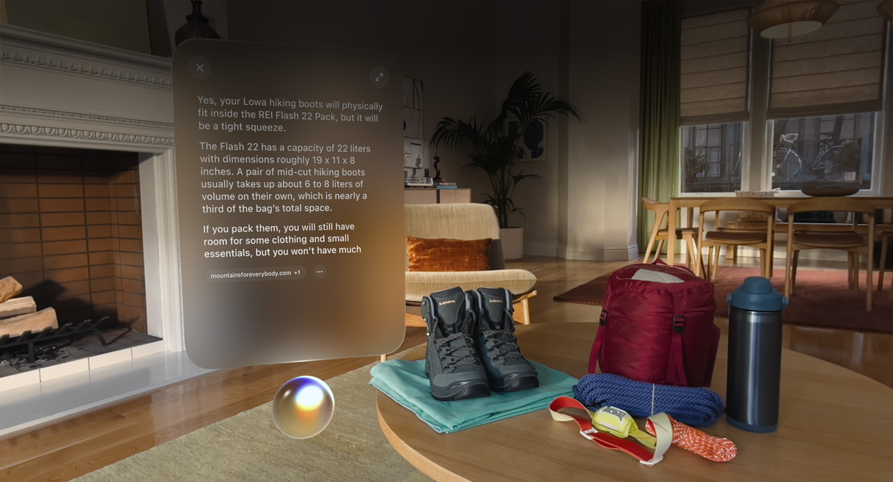 Vue d’un Apple Vision Pro, une conversation avec Siri pour savoir si des chaussures de randonnée rentrent dans un sac à dos apparaît au-dessus de Siri et à gauche d’une paire de chaussures de randonnée et d’autres équipements de plein air