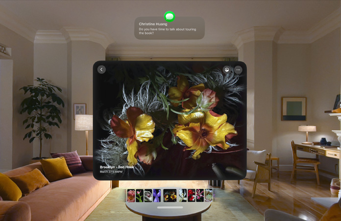 Un Apple Vision Pro agrandit un message à propos d'une tournée littéraire tout en affichant des images de fleurs